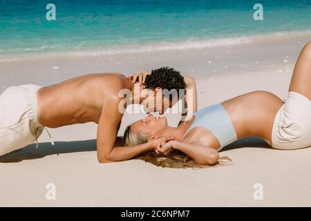 Junge schwangere Frau mit Mann entspannen im Paradies Strand. Glückliches Paar in den Tropen Stockfoto