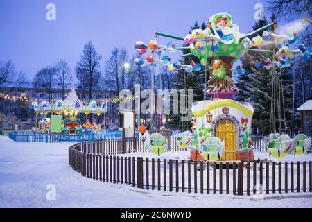 Das Kinderkarussell leuchtet im Winter wunderschön. Attraktion für Kinder Stockfoto