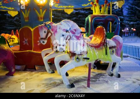 Das Kinderkarussell leuchtet im Winter wunderschön. Attraktion für Kinder Stockfoto