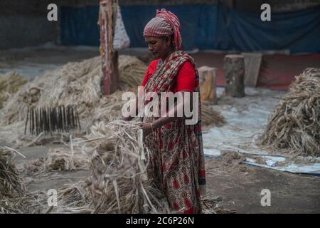 Narayanganj, Bangladesch. Juli 2020. Eine Frau arbeitet in einer Jute-Verarbeitungsfabrik in Narayanganj in der Nähe von Dhaka, Bangladesch.Jute, auch bekannt als die goldene Faser von Bangladesch, spielt eine wichtige Rolle in der nationalen Wirtschaft. Achtzig Prozent der weltweit hochwertigen Jute wächst in Bangladesch. Jute wird bei der Herstellung von Tuch, Schal, Seilen, Teppich-Trägertuch, Büchsenbeutel und viele andere nützliche Dinge verwendet. Jute-Beutel sind sehr gut geeignet für das Verpacken von Lebensmittelkörnern. Kredit: SOPA Images Limited/Alamy Live Nachrichten Stockfoto