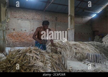 Narayanganj, Bangladesch. Juli 2020. Ein Mann, der in einer Jute-Verarbeitungsfabrik in Narayanganj in der Nähe von Dhaka, Bangladesch, arbeitet.Jute, auch bekannt als die goldene Faser von Bangladesch, spielt eine wichtige Rolle in der Volkswirtschaft. Achtzig Prozent der weltweit hochwertigen Jute wächst in Bangladesch. Jute wird bei der Herstellung von Tuch, Schal, Seilen, Teppich-Trägertuch, Büchsenbeutel und viele andere nützliche Dinge verwendet. Jute-Beutel sind sehr gut geeignet für das Verpacken von Lebensmittelkörnern. Kredit: SOPA Images Limited/Alamy Live Nachrichten Stockfoto