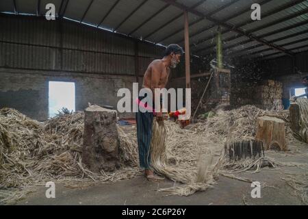 Narayanganj, Bangladesch. Juli 2020. Ein Mann, der in einer Jute-Verarbeitungsfabrik in Narayanganj in der Nähe von Dhaka, Bangladesch, arbeitet.Jute, auch bekannt als die goldene Faser von Bangladesch, spielt eine wichtige Rolle in der Volkswirtschaft. Achtzig Prozent der weltweit hochwertigen Jute wächst in Bangladesch. Jute wird bei der Herstellung von Tuch, Schal, Seilen, Teppich-Trägertuch, Büchsenbeutel und viele andere nützliche Dinge verwendet. Jute-Beutel sind sehr gut geeignet für das Verpacken von Lebensmittelkörnern. Kredit: SOPA Images Limited/Alamy Live Nachrichten Stockfoto