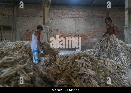 Narayanganj, Bangladesch. Juli 2020. Menschen, die in einer Jute-Verarbeitungsfabrik in Narayanganj bei Dhaka, Bangladesch, arbeiten.Jute, auch bekannt als die goldene Faser von Bangladesch, spielt eine wichtige Rolle in der nationalen Wirtschaft. Achtzig Prozent der weltweit hochwertigen Jute wächst in Bangladesch. Jute wird bei der Herstellung von Tuch, Schal, Seilen, Teppich-Trägertuch, Büchsenbeutel und viele andere nützliche Dinge verwendet. Jute-Beutel sind sehr gut geeignet für das Verpacken von Lebensmittelkörnern. Kredit: SOPA Images Limited/Alamy Live Nachrichten Stockfoto