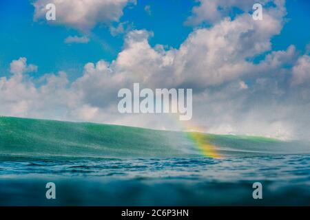 Regenbogen durch große Welle im Ozean. Brechende Welle, Tropfen und Regenbogen Stockfoto