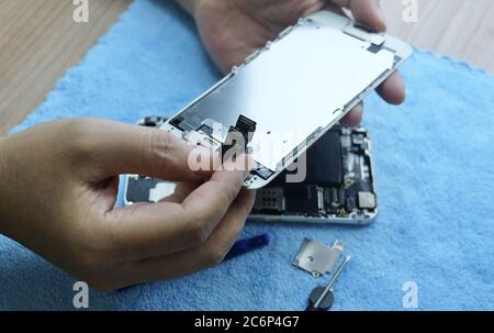 Nahaufnahme des Technikers Smartphone mit Schraubendreher auf dem Tisch öffnen und reparieren. Stockfoto