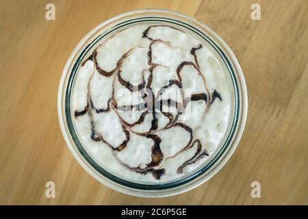Mokka Kaffee und Schokolade Kunst auf Milchschaum in der Mitte Rahmen auf Holz Hintergrund in Vintage-Ton Stockfoto