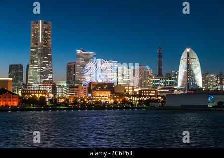 Die Skyline des Minato Mirai Viertels in Yokohama leuchtet bei Sonnenuntergang. Stockfoto