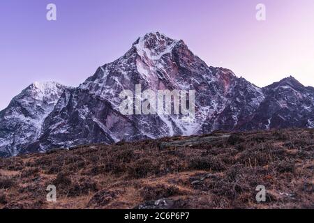 Die Wärme der Lodge lässt sich bei Dunkelheit verlassen, um den purpurnen Dunst über dem berüchtigten Cholatse-Gipfel im Himalaya in Nepal zu fangen. Stockfoto