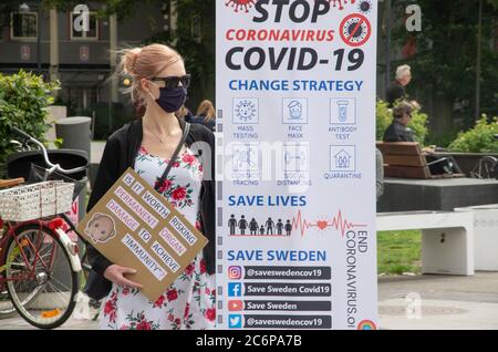 Malmö, Schweden. Juli 2020. Vor dem Bahnhof Triangeln in Malmö fand ein Protestakt gegen die schwedischen „laxen“ Coronavirus-Maßnahmen statt. Eine kleine Gruppe von Aktivisten zeigte Informationen über die Ausbreitung des Coronavirus im Land und ermutigte die Menschen, Gesichtsmaske zu verwenden, um die Ausbreitung des Virus zu verhindern. Sie gaben den Menschen kostenlose Gesichtsmasken und informierten, dass Schweden der 6. Versuch sei, mit mehr Todesfällen pro Kopf aufgrund von Covid-19. Kredit: Lora Grigorova/Alamy Live Nachrichten Stockfoto