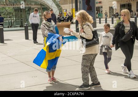 Malmö, Schweden. Juli 2020. Vor dem Bahnhof Triangeln in Malmö fand ein Protestakt gegen die schwedischen „laxen“ Coronavirus-Maßnahmen statt. Eine kleine Gruppe von Aktivisten zeigte Informationen über die Ausbreitung des Coronavirus im Land und ermutigte die Menschen, Gesichtsmaske zu verwenden, um die Ausbreitung des Virus zu verhindern. Sie gaben den Menschen kostenlose Gesichtsmasken und informierten, dass Schweden der 6. Versuch sei, mit mehr Todesfällen pro Kopf aufgrund von Covid-19. Kredit: Lora Grigorova/Alamy Live Nachrichten Stockfoto