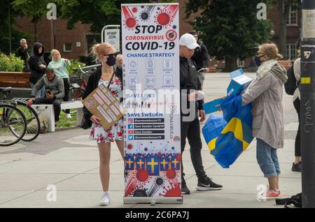 Malmö, Schweden. Juli 2020. Vor dem Bahnhof Triangeln in Malmö fand ein Protestakt gegen die schwedischen „laxen“ Coronavirus-Maßnahmen statt. Eine kleine Gruppe von Aktivisten zeigte Informationen über die Ausbreitung des Coronavirus im Land und ermutigte die Menschen, Gesichtsmaske zu verwenden, um die Ausbreitung des Virus zu verhindern. Sie gaben den Menschen kostenlose Gesichtsmasken und informierten, dass Schweden der 6. Versuch sei, mit mehr Todesfällen pro Kopf aufgrund von Covid-19. Kredit: Lora Grigorova/Alamy Live Nachrichten Stockfoto