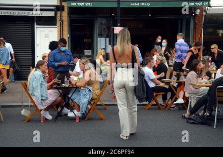 London, Großbritannien. Juli 2020. Northcote Road in Battersea, Wandsworth Fußgänger an den Wochenenden durch den rat erlaubt Restaurants, Tische und Stühle in der Straße zu setzen, um zu helfen, sich finanziell nach der Coronavirus Sperre. Dies ist eine beliebte Straße für Pubs und Restaurants. Kredit: JOHNNY ARMSTEAD/Alamy Live Nachrichten Stockfoto