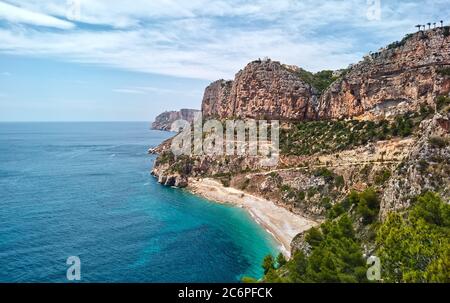 Luftaufnahme Drohne Blickpunkt malerische Cala del Moraig in Benitachell Küstenstadt. Hell türkisfarbenes Wasser Bucht des Mittelmeers weißen Sand Stockfoto