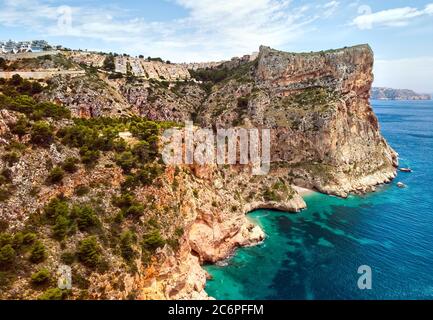 Luftaufnahme Drohne Blickpunkt malerische Cala del Moraig in Benitachell Küstenstadt. Hell türkisfarbenes Wasser Bucht des Mittelmeers weißen Sand Stockfoto