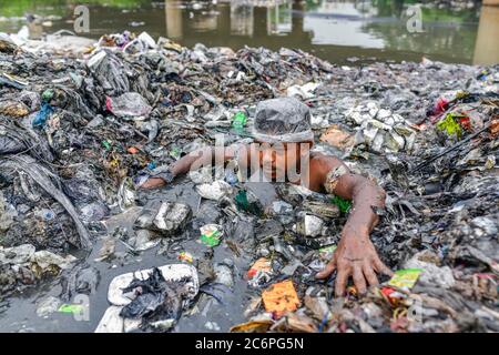 Savar, Bangladesch. Juli 2020. Ein Freiwilliger ist Hals tief in Müll, während der Arbeit, um einen Kanal von städtischen Abfällen in der Nähe von Dhaka verstopft reinigen. Kredit: Zabed Hasnain Chowdhury/ZUMA Wire/Alamy Live Nachrichten Stockfoto