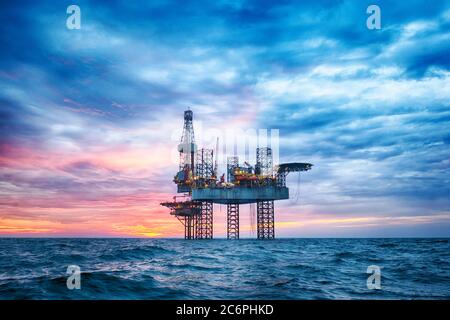 HDR von Offshore Jack Up Rig in der Mitte des Meeres bei Sonnenuntergang Stockfoto