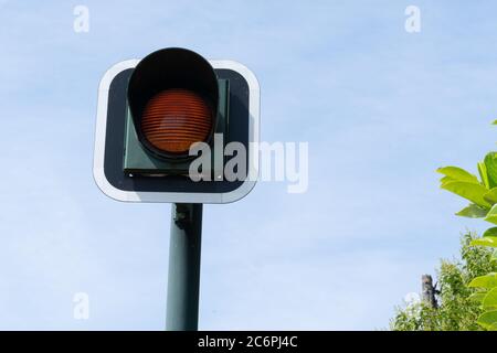 Gelb blinkende orange Ampel Signal für Autos blauen Himmel Hintergrund  Stockfotografie - Alamy