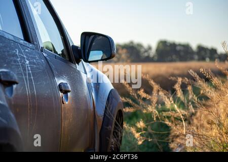 Landschaft mit braunem Geländewagen auf Schotterstraße. Reisen im Auto, Abenteuer in der Tierwelt, Expedition oder extreme Reise auf einem SUV-Automobil. Offroad Stockfoto