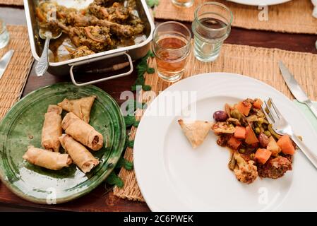 Essen und Wein aus dem Nahen Osten auf einem Holztisch mit gewebten Tischsets Stockfoto
