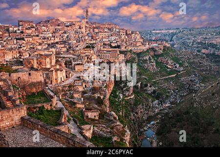 Matera, Basilicata, Italien: Landschaft bei Sonnenaufgang der Altstadt Sassi und der Bach am Fuße der tiefen Schlucht Stockfoto