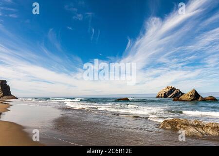 Blauer Himmel mit hohen Wolken über dem Meer stapelt sich am Bandon Beach in Oregon Stockfoto