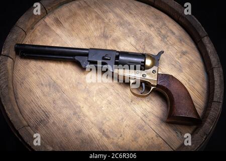 Old West Weapon - Schlagzeugwaffe Armee Revolver auf Holzfass Stockfoto