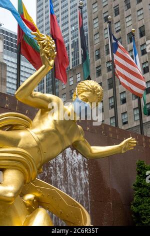 Prometheus im Rockefeller Center verfügt über eine riesige Gesichtsmaske wegen der Coronavirus-Pandemie, USA Stockfoto