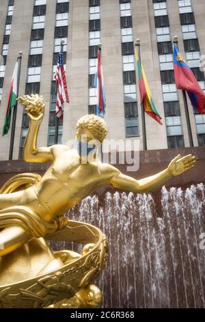 Prometheus im Rockefeller Center verfügt über eine riesige Gesichtsmaske wegen der Coronavirus-Pandemie, USA Stockfoto