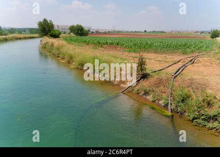 Die Pumpstation, wo Wasser aus einem Bewässerungskanal gepumpt wird und auf Bewässerungssprinkler in landwirtschaftlichen Feldern verteilt wird. Stockfoto