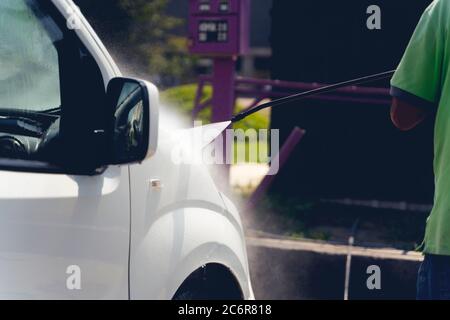 Manuelle Autowäsche mit Wasser unter Druck in car wash außerhalb. Stockfoto