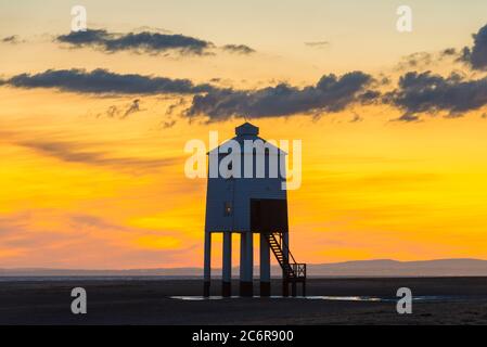 Burnham-on-Sea, Somerset, Großbritannien. Juli 2020. Wetter in Großbritannien. Ein dramatischer goldener Sonnenuntergang am historischen Leuchtturm Low, der vom Strand von Burnham-on-Sea in Somerset am Ende eines heißen, sonnigen Tages betrachtet wird. Der neunbeinige Leuchtturm aus Holz wurde 1832 erbaut und ist unter Denkmalschutz der Stufe II. Bildquelle: Graham Hunt/Alamy Live News Stockfoto