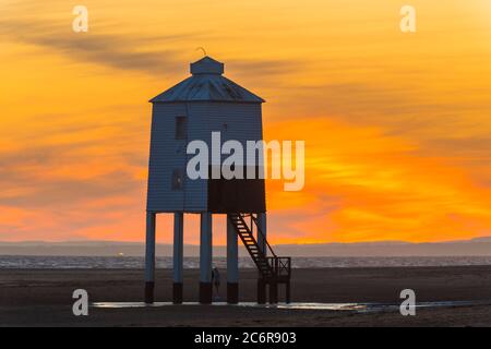 Burnham-on-Sea, Somerset, Großbritannien. Juli 2020. Wetter in Großbritannien. Ein dramatischer goldener Sonnenuntergang am historischen Leuchtturm Low, der vom Strand von Burnham-on-Sea in Somerset am Ende eines heißen, sonnigen Tages betrachtet wird. Der neunbeinige Leuchtturm aus Holz wurde 1832 erbaut und ist unter Denkmalschutz der Stufe II. Bildquelle: Graham Hunt/Alamy Live News Stockfoto