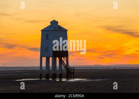 Burnham-on-Sea, Somerset, Großbritannien. Juli 2020. Wetter in Großbritannien. Ein dramatischer goldener Sonnenuntergang am historischen Leuchtturm Low, der vom Strand von Burnham-on-Sea in Somerset am Ende eines heißen, sonnigen Tages betrachtet wird. Der neunbeinige Leuchtturm aus Holz wurde 1832 erbaut und ist unter Denkmalschutz der Stufe II. Bildquelle: Graham Hunt/Alamy Live News Stockfoto