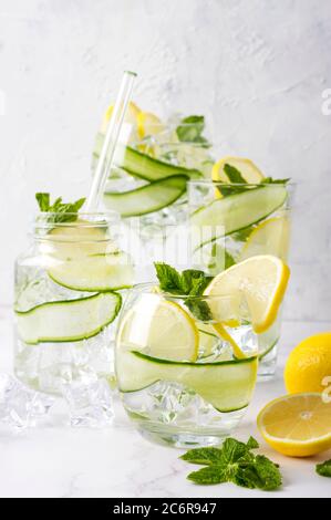 Alkoholgetränk (Gin Tonic Cocktail) mit Zitrone, Gurke, Minzblättern und Eis auf Weiß. Eisgetränk mit Zitrone. Stockfoto