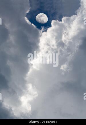 Dramatische Wolken umrahmen einen fast Vollmond. Stockfoto