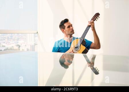 Portrait Of Adult Man Spielt Klassische Gitarre Und Gesang Stockfoto