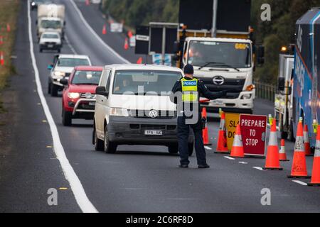 Melbourne, Australien 11. Juli 2020 leitet ein Polizeibeamter den Verkehr in eine der Straßensperren am Western Highway in Victoria, die gegründet wurden, um die Ausbreitung des Corona-Virus in Australiens zweitbevölkerungsreichster Bundesstaat einzudämmen. Kredit: Michael Currie/Alamy Live Nachrichten Stockfoto