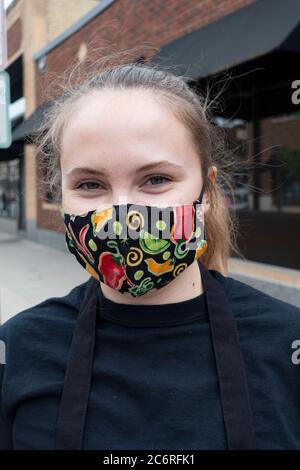 Kellner mit Maske aus dem Cafe Latte, der einen Bordservice für die Lieferung von Speisen bietet. St. Paul Minnesota, USA Stockfoto