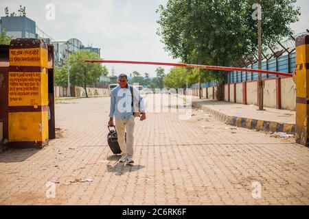 Ghaziabad, Indien. Juli 2020. Ein Mann macht einen langen Spaziergang zurück nach Hause von einer verlassenen Bushaltestelle inmitten der Lockdown.Uttar Pradesh verhängen eine 55 Stunden Sperre, wo alle nicht-wesentlichen Dienste wurden ausgesetzt nach einer schnellen Zunahme der Coronavirus-Fälle für die letzten Tage. Kredit: SOPA Images Limited/Alamy Live Nachrichten Stockfoto
