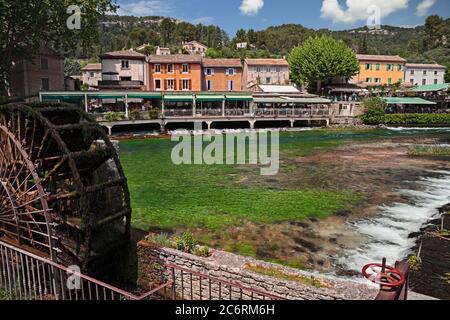 Fontaine-de-Vaucluse, Provence-Alpes-Cote d'Azur, Frankreich: Landschaft des Dorfes mit dem grünen Fluss Sorgue und einem Wassermühlenrad Stockfoto