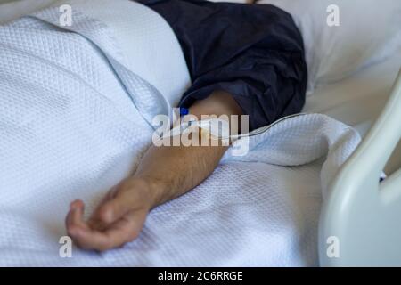 Männlicher Patient mit einem Serum im Krankenhaus Stockfoto