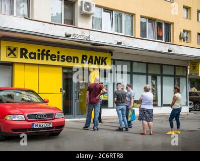 Bukarest/Rumänien - 05.16.2020: Menschen warten in der Schlange vor einer Raiffeisein Bankfiliale, die die soziale Distanzierung respektiert, um die zu verhindern und zu stoppen Stockfoto