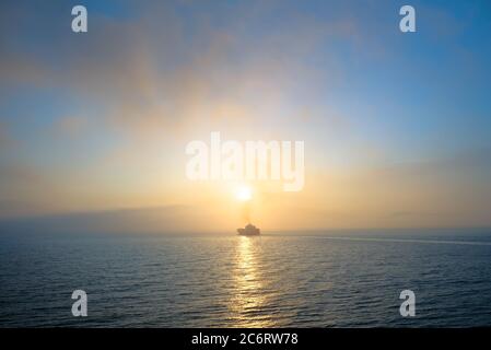 Sonnenaufgang auf dem Meer, entfernte Schiffshilhouette Stockfoto