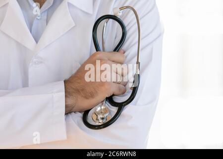 Nahaufnahme männlichen Arzt trägt weiße Uniform hält Stethoskop Stockfoto