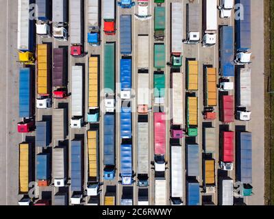 Viele Lastwagen auf dem Parkplatz, eine Warteschlange von Lastwagen zum Entladen. Draufsicht. Konzept von Transport und Logistik Stockfoto