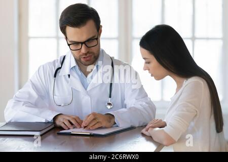 Männlich Arzt Beratung weiblichen Patienten bei der Sitzung, geben Rezept Stockfoto