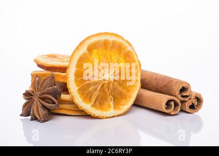 Glühwein Zubereitung Konzept. Weihnachtsdekoration Konzept. Nahaufnahme von getrockneten Orangenscheiben Zimtschnecken und Anis isoliert auf weißem Hintergrund Stockfoto