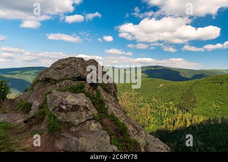 Felsformation Rysi skala oberhalb des Dorfes Kouty nad Desnou mit dem Praded Hügel im Hintergrund im Jeseniky Gebirge in Tschechien Stockfoto