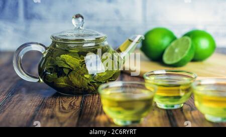 Die Teeblätter werden in kochendem Wasser gebrüht und in eine kleine Teekanne gegeben. Das Konzept der Tee-Party. Grüner Tee in einer Teekanne Stockfoto