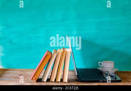 homeoffice Arbeitsplatz, mit Computer, Bücher, Bürobedarf und Kaffee, Lockdown Corona Virus. Stockfoto